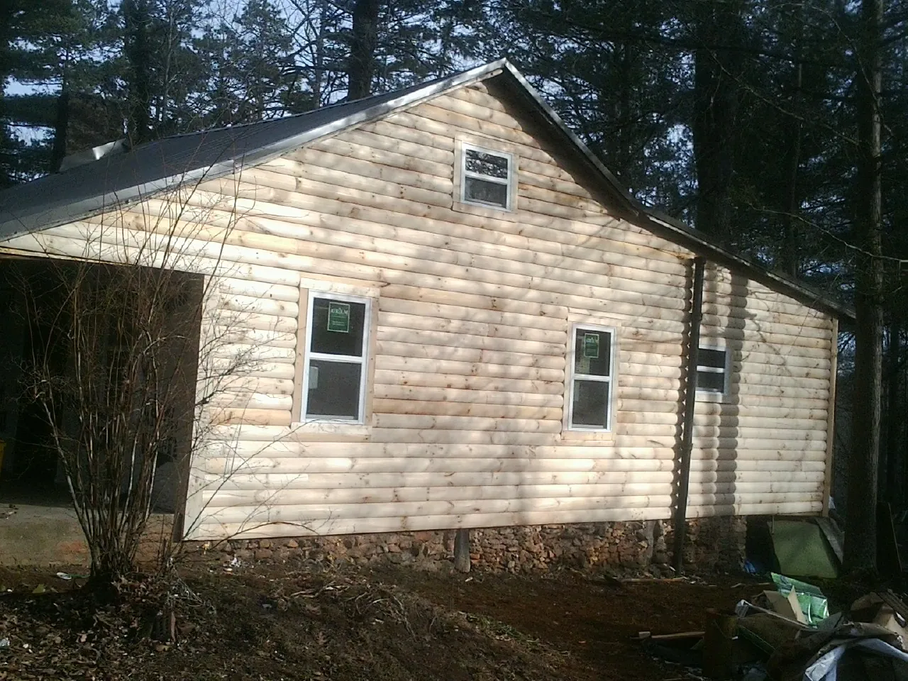 New log siding and dark metal roofing on a gable end in Vicksburg