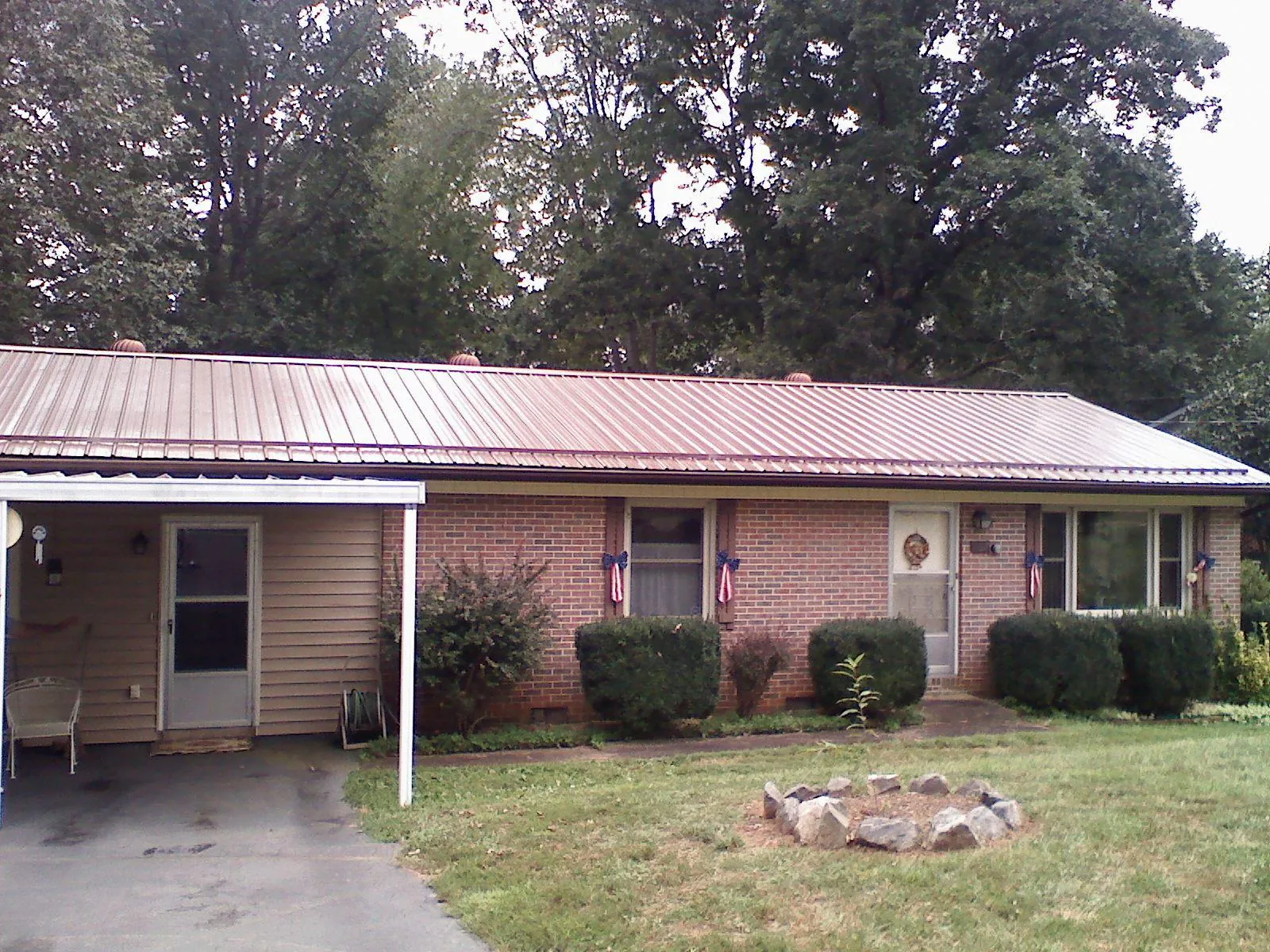 Bronze metal roof and carport on a brick ranch home — Roof Repair work by our crew in Vicksburg